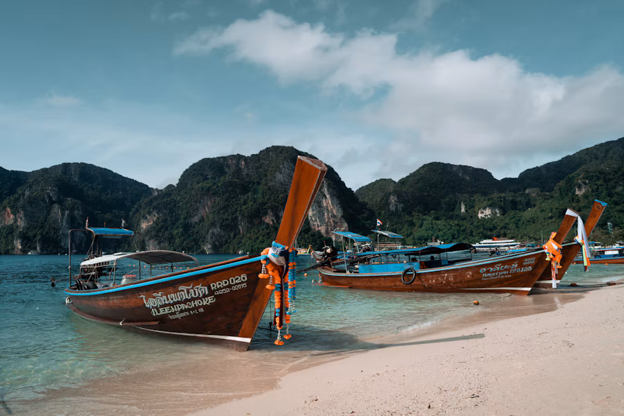 Traditional long-tail boats anchored in clear water in southern Thailand